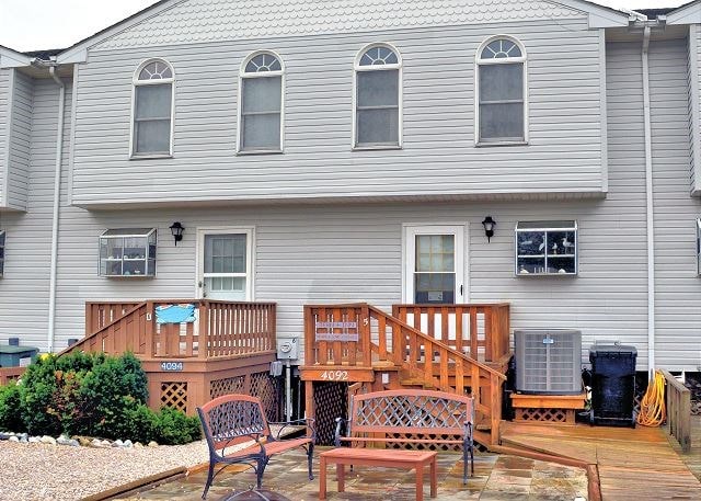 back of house featuring central AC, a deck, and a patio area