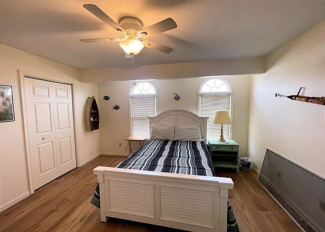 bedroom featuring dark hardwood / wood-style flooring, ceiling fan, and a closet