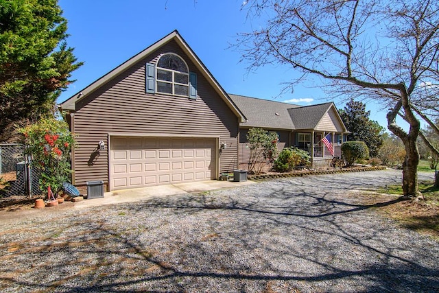 view of front of home with a porch, driveway, fence, and an attached garage