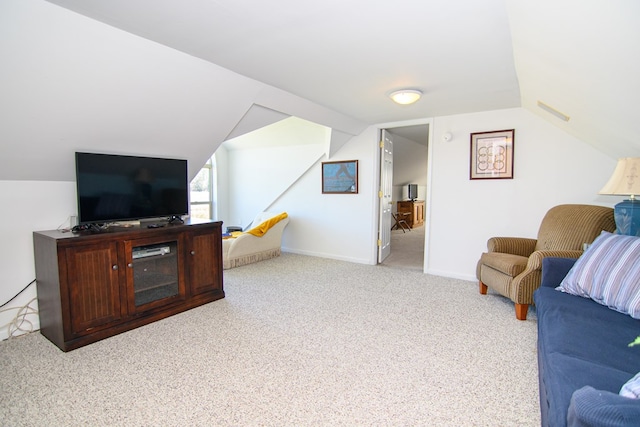 carpeted living area with baseboards and lofted ceiling