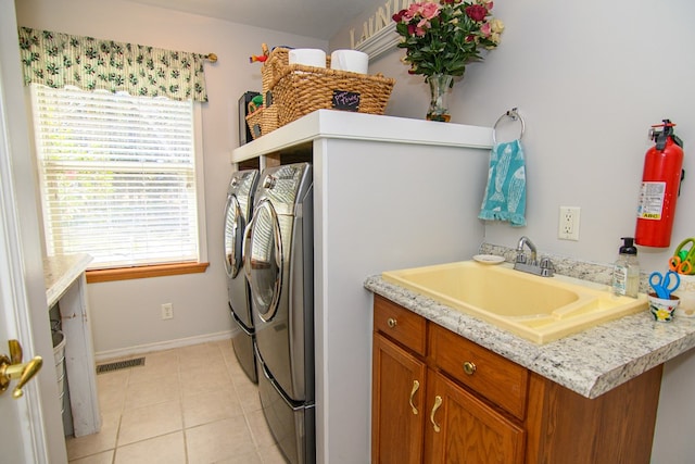 laundry room featuring washer and clothes dryer, a sink, light tile patterned flooring, visible vents, and laundry area