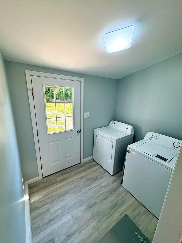 laundry area featuring washer and dryer and light hardwood / wood-style floors