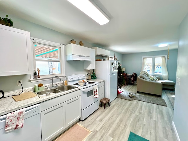 kitchen with light hardwood / wood-style floors, white cabinetry, white appliances, and sink