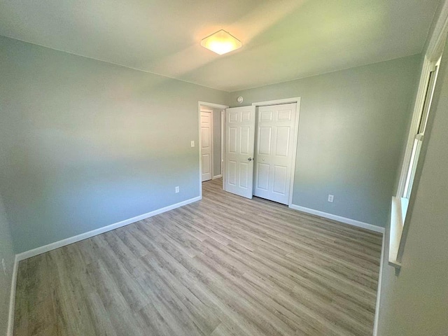 unfurnished bedroom with light hardwood / wood-style flooring and a closet