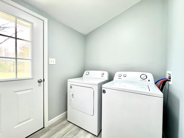 laundry room featuring washer and clothes dryer and light hardwood / wood-style floors