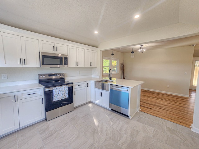 5065 Cobbs Station Rd, Cape Charles, VA 23310 - kitchen featuring appliances with stainless steel finishes, a peninsula, a textured ceiling, light countertops, and white cabinetry
