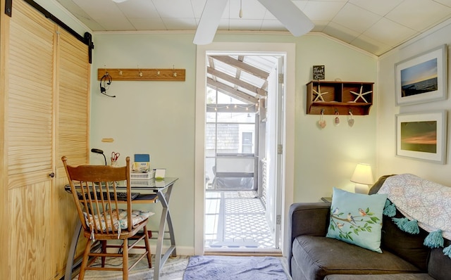 entryway with a wealth of natural light, crown molding, lofted ceiling, and a barn door