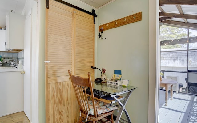 dining room featuring light wood-style flooring and a barn door