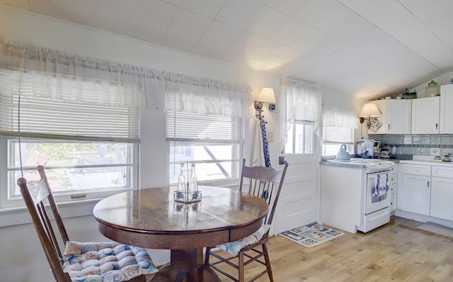 dining space with lofted ceiling and light wood-style flooring