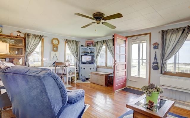 living area with a ceiling fan and wood finished floors