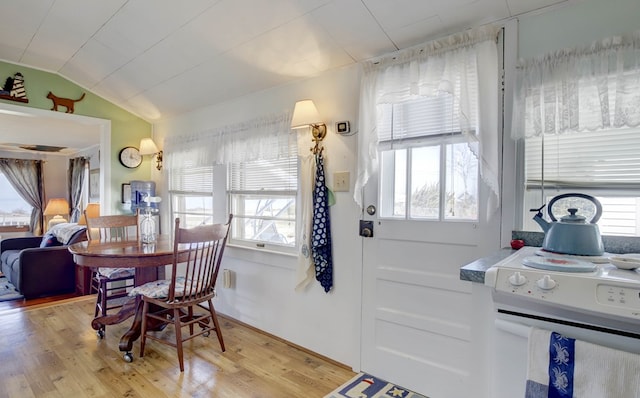 dining space with vaulted ceiling, plenty of natural light, and light wood-style flooring