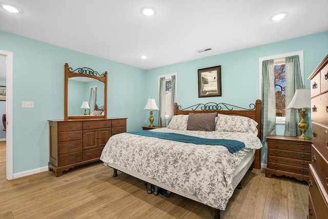 bedroom with baseboards, light wood-style flooring, visible vents, and recessed lighting