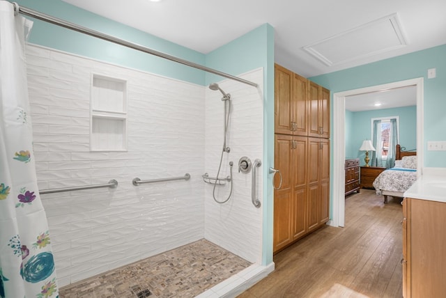 full bathroom with wood finished floors and a tile shower