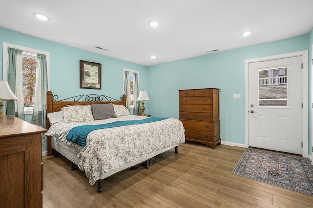 bedroom with baseboards, visible vents, wood finished floors, and recessed lighting