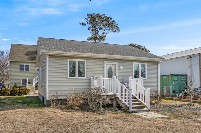 bungalow-style home featuring a shingled roof and a front lawn