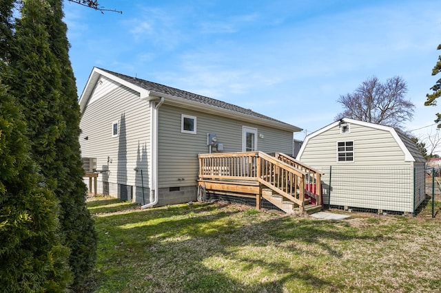 rear view of house featuring a deck, an outdoor structure, crawl space, a lawn, and a storage unit