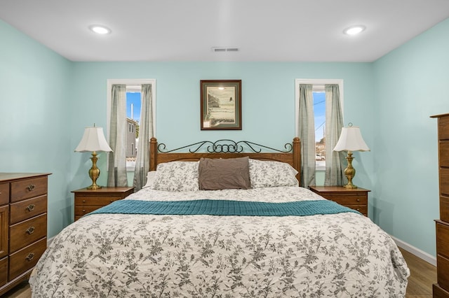 bedroom with baseboards, visible vents, wood finished floors, and recessed lighting