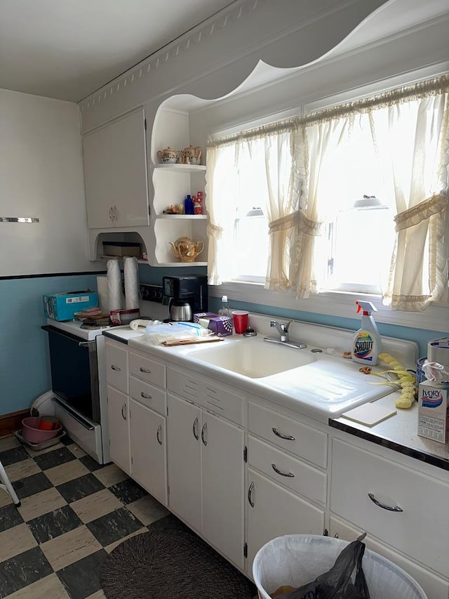 3533 Ridge Rd, Chincoteague, VA 23336 - kitchen featuring stove, white cabinets, light floors, and open shelves