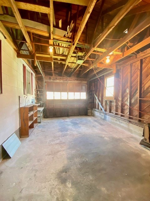 garage with concrete block wall and a garage door opener