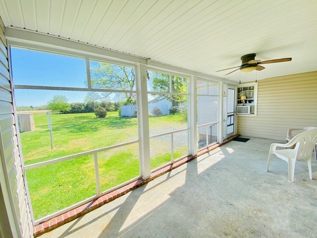 unfurnished sunroom with a ceiling fan and cooling unit