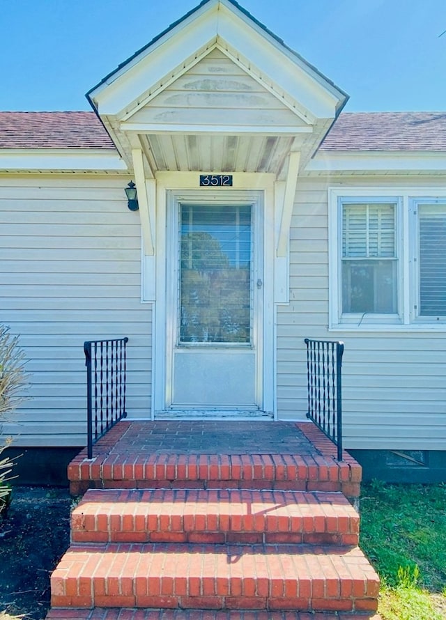 entrance to property with a shingled roof