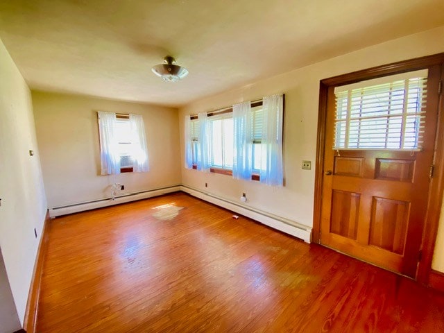 entryway featuring baseboard heating, baseboards, a baseboard heating unit, and wood finished floors