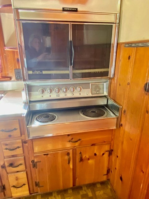 interior details featuring brown cabinets, light countertops, and oven