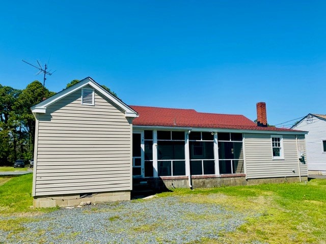 rear view of property with a sunroom and a lawn