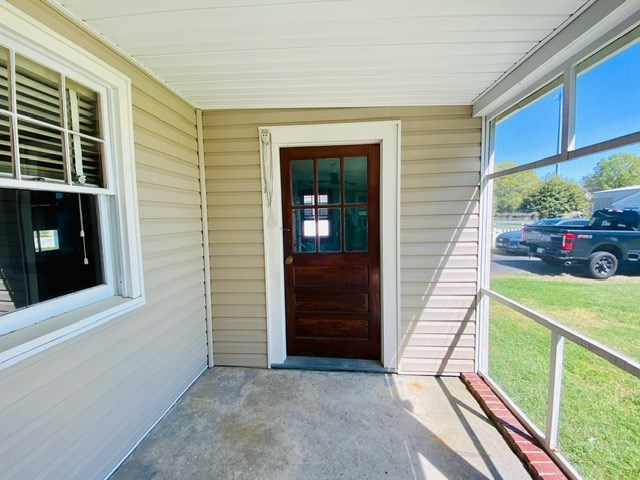 view of exterior entry with a lawn