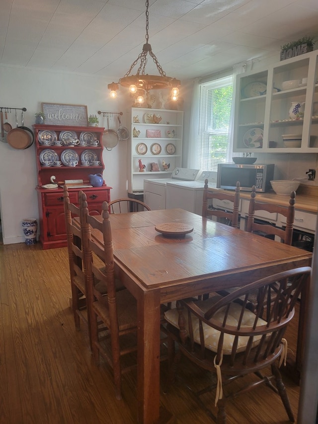 dining room with hardwood / wood-style flooring and independent washer and dryer