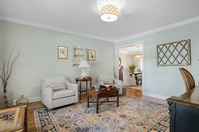 living area with a notable chandelier, crown molding, and wood finished floors