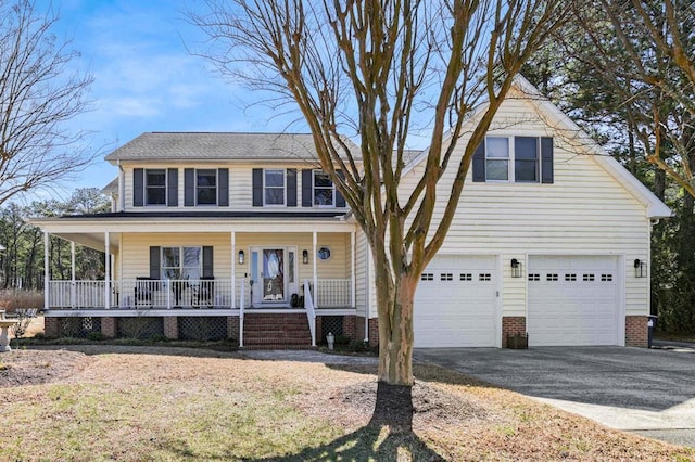 view of front of home with a porch, driveway, and a garage