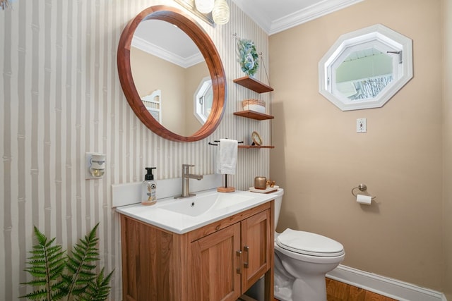 bathroom featuring vanity, crown molding, toilet, and baseboards