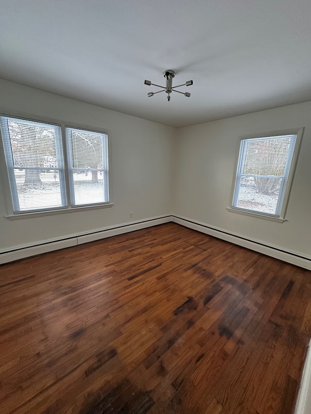 unfurnished room with a baseboard radiator and dark wood-type flooring