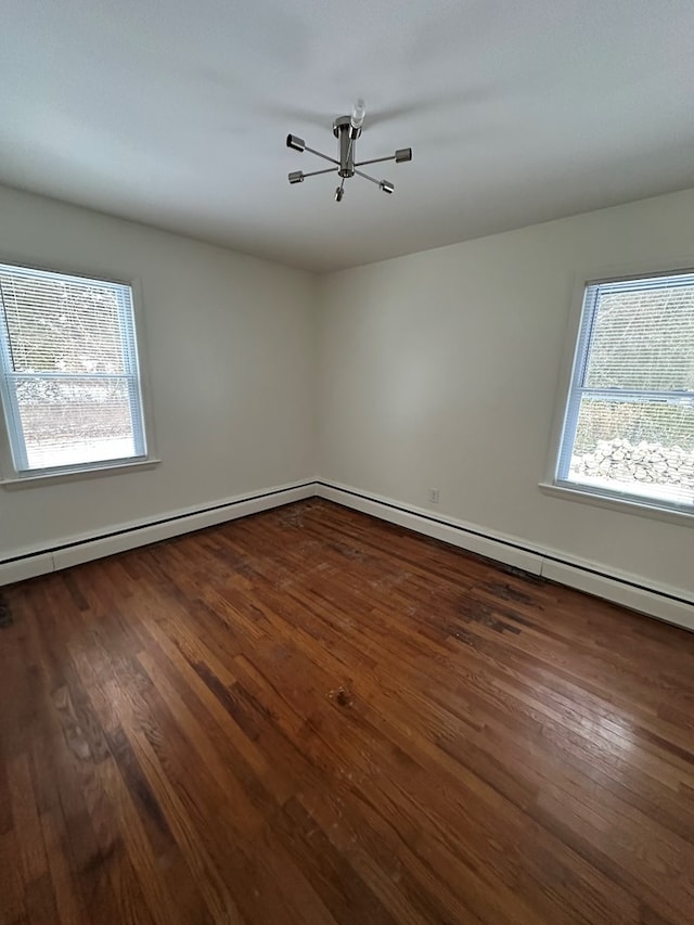 spare room with a wealth of natural light and dark hardwood / wood-style floors