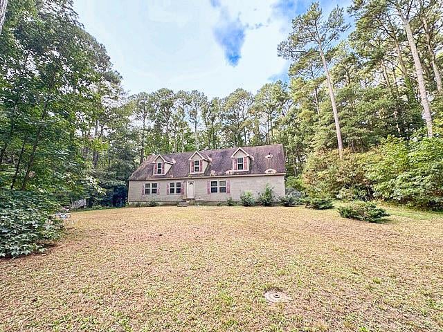 cape cod house with a front yard