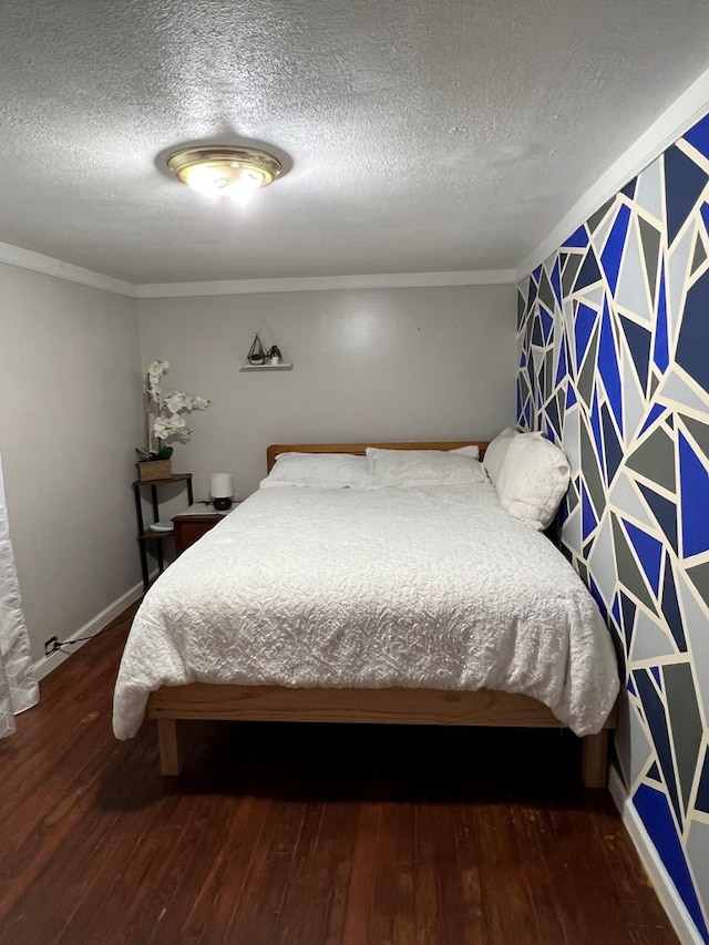 bedroom with crown molding, a textured ceiling, baseboards, and wood finished floors