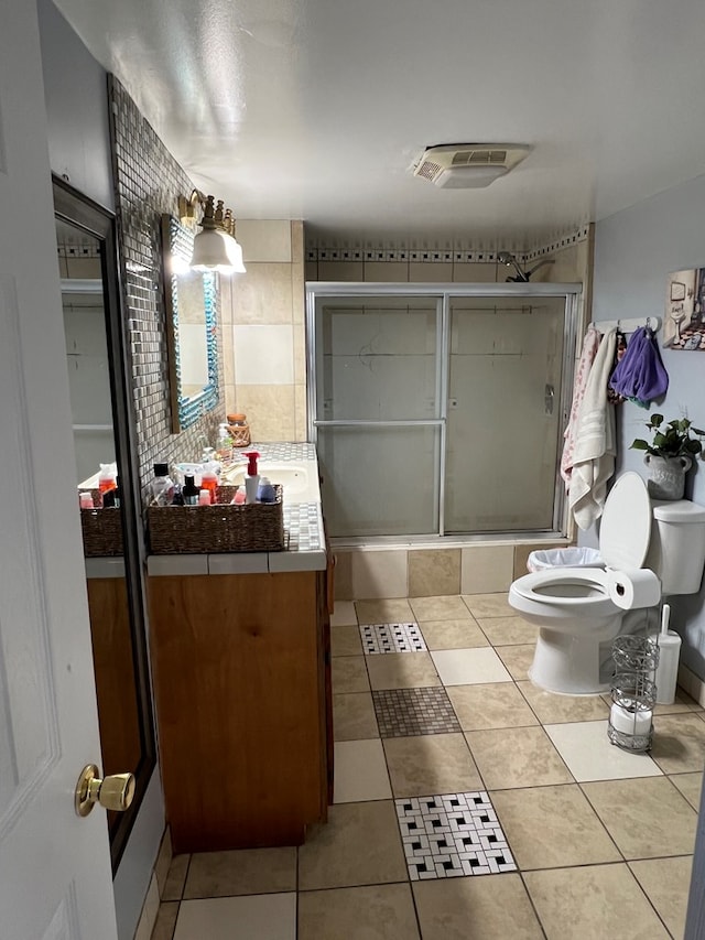 full bath with toilet, shower / bath combination with glass door, visible vents, vanity, and tile patterned floors