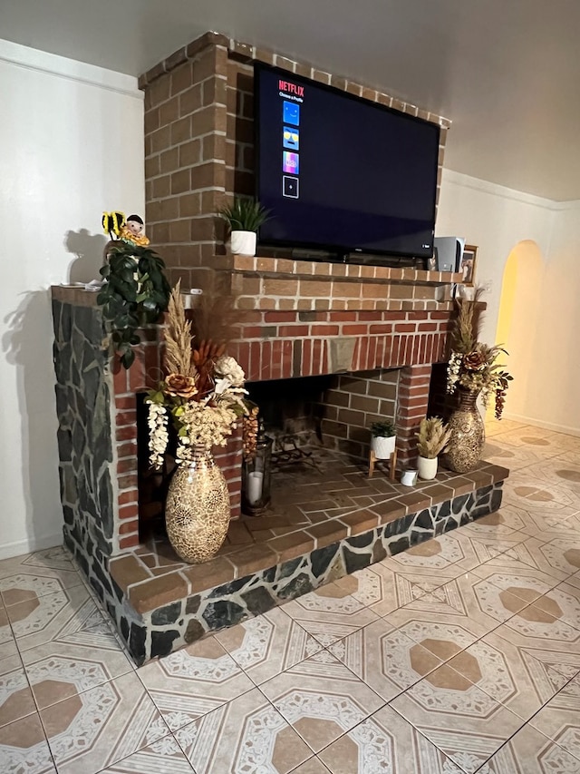 interior details featuring arched walkways, a brick fireplace, and baseboards