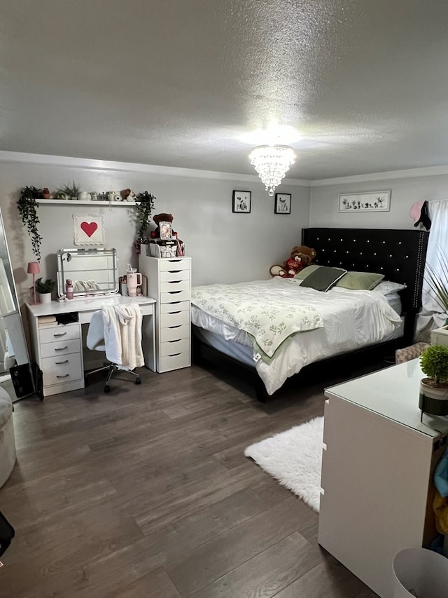 bedroom featuring a textured ceiling, a chandelier, dark wood-style flooring, and ornamental molding