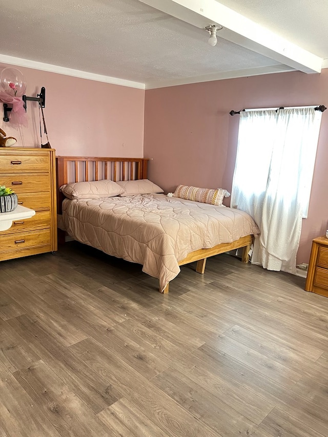 bedroom with a textured ceiling and wood finished floors