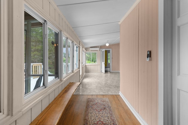 14457 Broadway Rd, Onancock, VA 23417 - hallway with light wood-style flooring, wood walls, and a wall unit AC