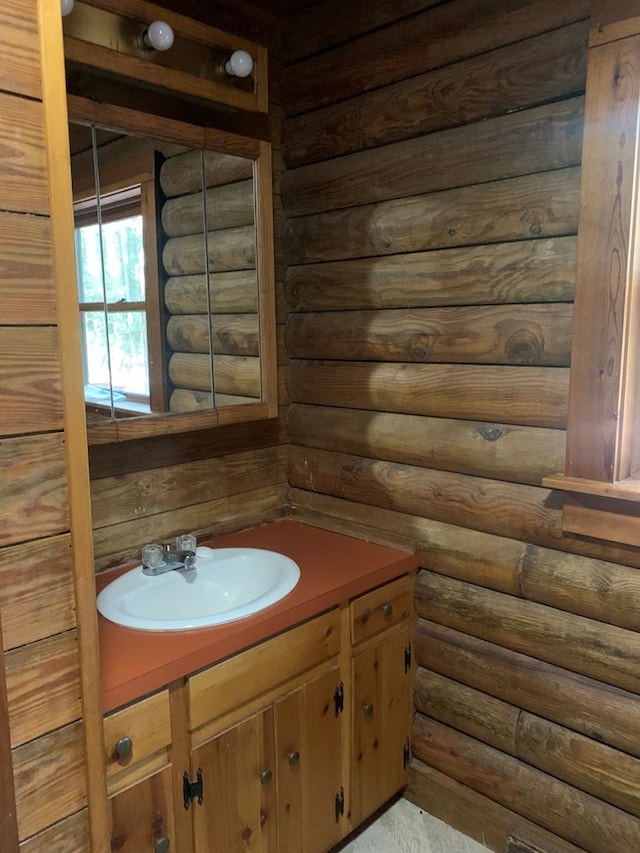 bathroom featuring vanity and log walls