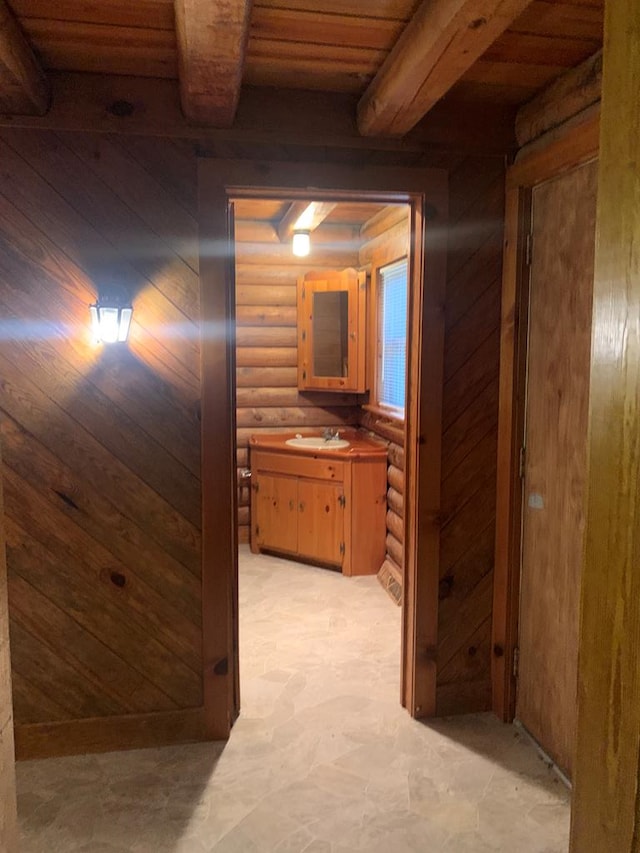 corridor featuring beam ceiling, sink, log walls, and wood ceiling