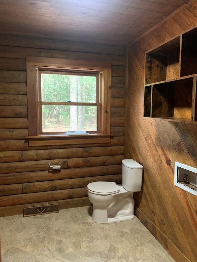 bathroom featuring wooden ceiling, toilet, and wooden walls