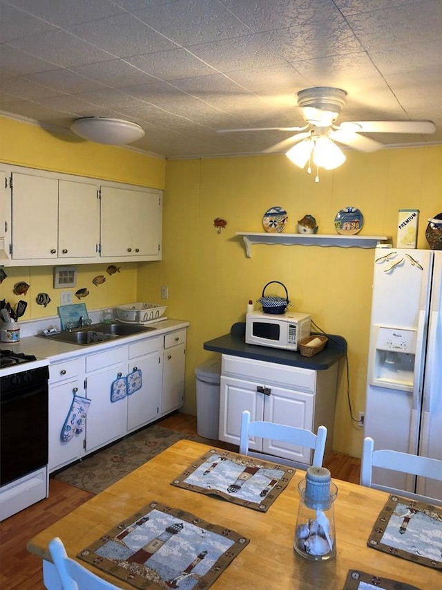 2561 Captains Corridor, Greenbackville, VA 23356 - kitchen with white appliances, white cabinetry, a ceiling fan, a sink, and wood finished floors