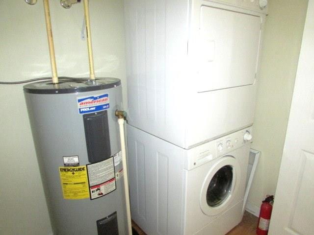 washroom featuring electric water heater and stacked washer and clothes dryer