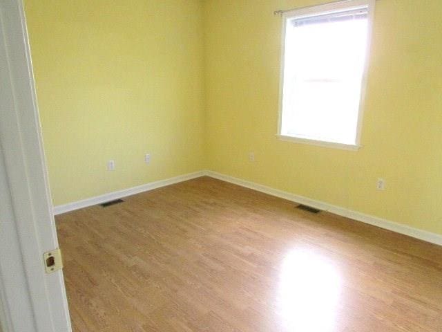 spare room with wood-type flooring