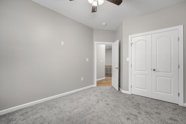 unfurnished bedroom featuring baseboards, carpet flooring, a ceiling fan, and a closet
