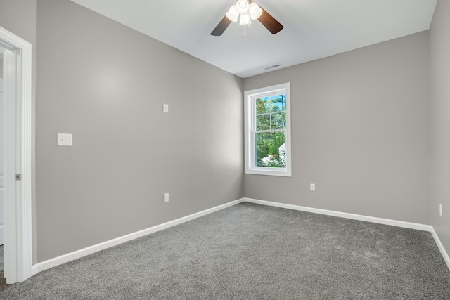 carpeted empty room with baseboards, ceiling fan, and visible vents